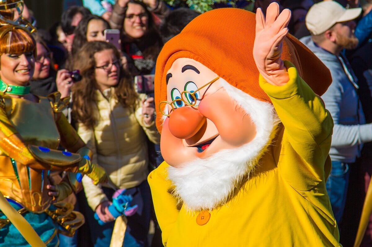 Chef / Doc Der Zwerg Chef / Doc aus Schneewittchen läuft winkend am Publikum auf der Main Street, U.S.A. vorbei