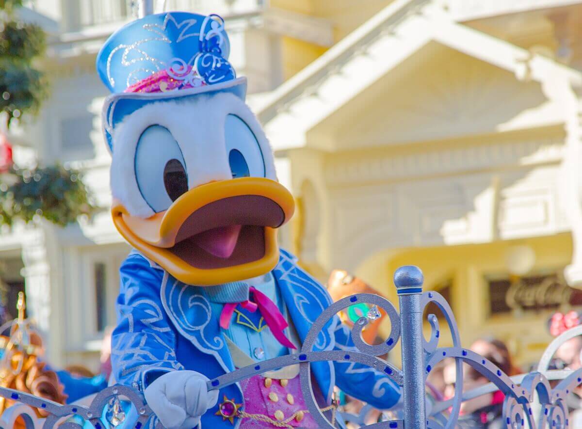Donald Duck Donald Duck in einem hellblauen Anzug und Zylinder mit silberfarbenen Applikationen, speziell für den 25. Geburtstag von Disneyland Paris