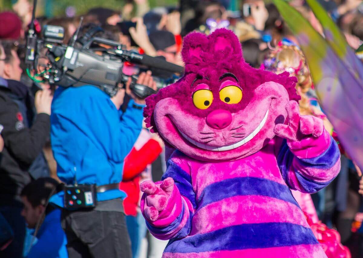 Grinsekatze Die Grinsekatze und neben ihr Alice im Wunderland mit einem breiten Lächeln im Gesicht
