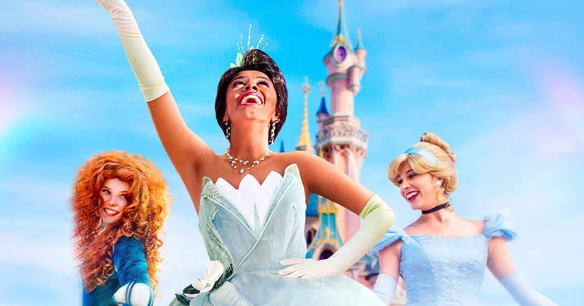 World Princess Week Disneyland Paris Tiana, Merida und Cinderella posieren für die Kamera. Im Hintergrund ist das Sleeping Beauty Castle aus Disneyland Paris zu sehen