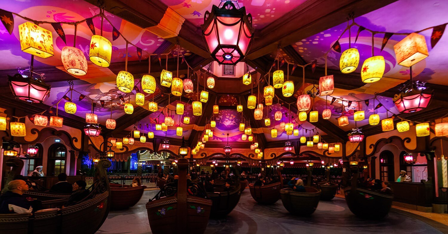 Raiponce Tangled Spin Karussell Hölzerne Boote unter einem Lampion-Himmel im Karussell Raiponce Tangled Spin bei Nacht