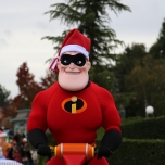 Mr. Incredibel auf einem Segwy. Er trägt sein Superheldenoutfit, eine schwarze Maske über den Augen und eine Weihnachtsmannmütze