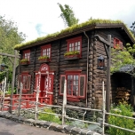 Holzhaus mit roten Fenster- und Türrahmen