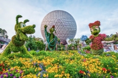 Der Eingang von Epcot mit Pluto Daisy und Goofy in Buchsbaumform