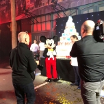 Mickey Mouse lässt sich neben seinem Geburtstagskuchen fotografieren