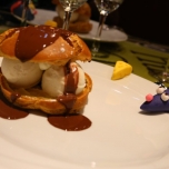 Profiterol mit Eiscremefüllung und Scholoadensauce, am Tellerrand Marzipanfiguren, die ein Stück Käse und die Ratte Remy zeigen