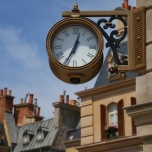 Große Uhr mit römischem Ziffernblatt an einem Haus befestigt