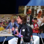 Tracy Eck sitzt in einem Sessel, dahinter Fotos von Walt Disney