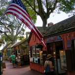 US-Flagge weht vor einem rot-braunen Holzhaus