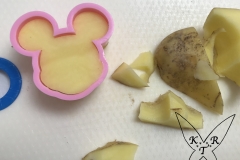 Mit einem Ausstechförmchen in Mickey Mouse-Form wird die Kartoffel ausgestochen