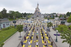 Blick von der Main Street auf den Central Plaza, wo sich zahlreiche Menschen auf gelben Yogamatten befinden