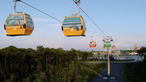 Bunte Gondeln des Disney Skyliner Transportsystems schweben in der Luft über dem Walt Disney World