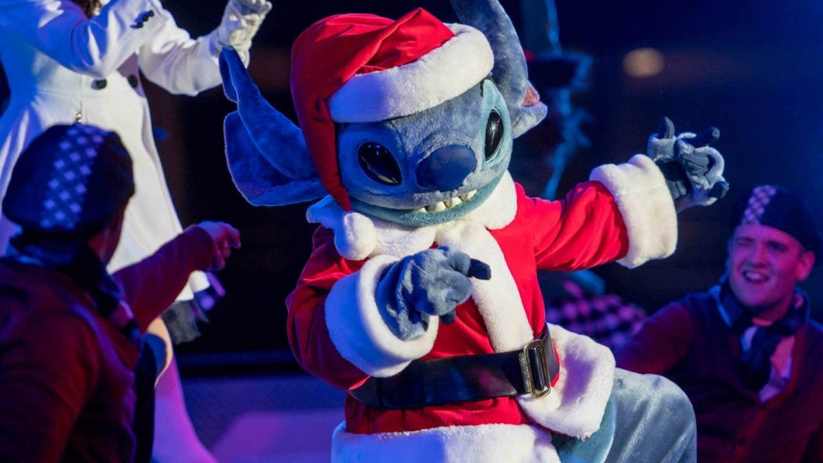 Stitch tanzt in seinem Weihnachtsmannkostüm fröhlich über die Bühne