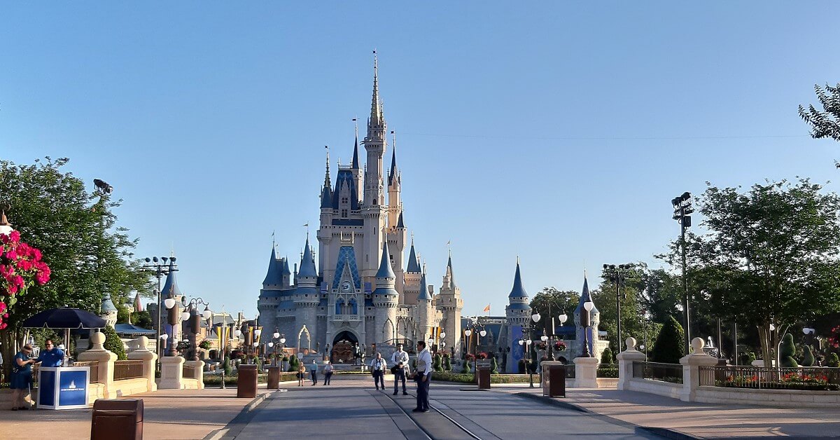 Cinderella Castle in einem leeren Magic Kingdom, in dem nur ein paar Cast Member zu sehen sind