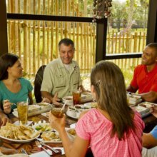 Mehrere Besucher essen gemeinsam mit einem Tierspezialisten im Sanaa in der Animal Kingdom Lodge