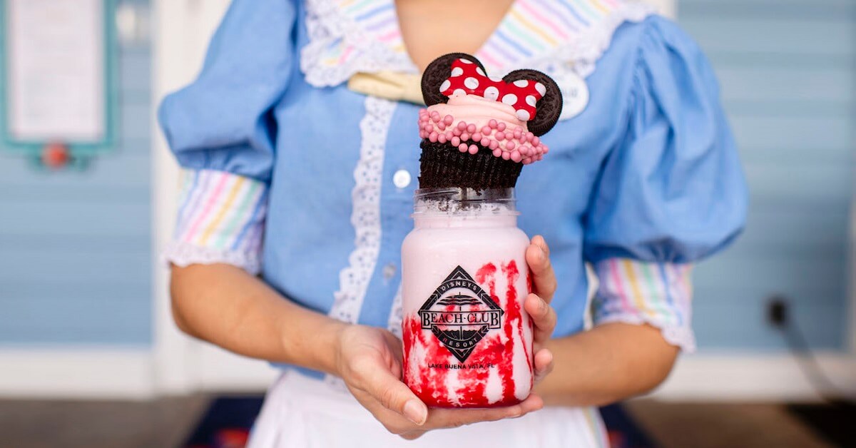 Eine Mitarbeiterin aus dem Beaches & Cream Soda Shop hält einen Minnie Milchshake in ihren Händen