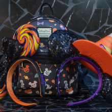 An einen Loungefly-Rucksack mit Halloween-Print sind zwei verschiedene Minnie-Haarreifen in Halloween-Designs gelehnt