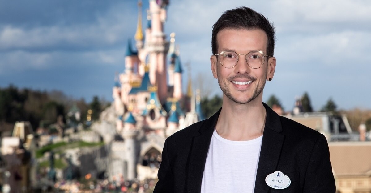 Der Cosmetology Designer Nicolas Cueff steht im Disneyland Park vor dem Dornröschenschloss im Hintergrund