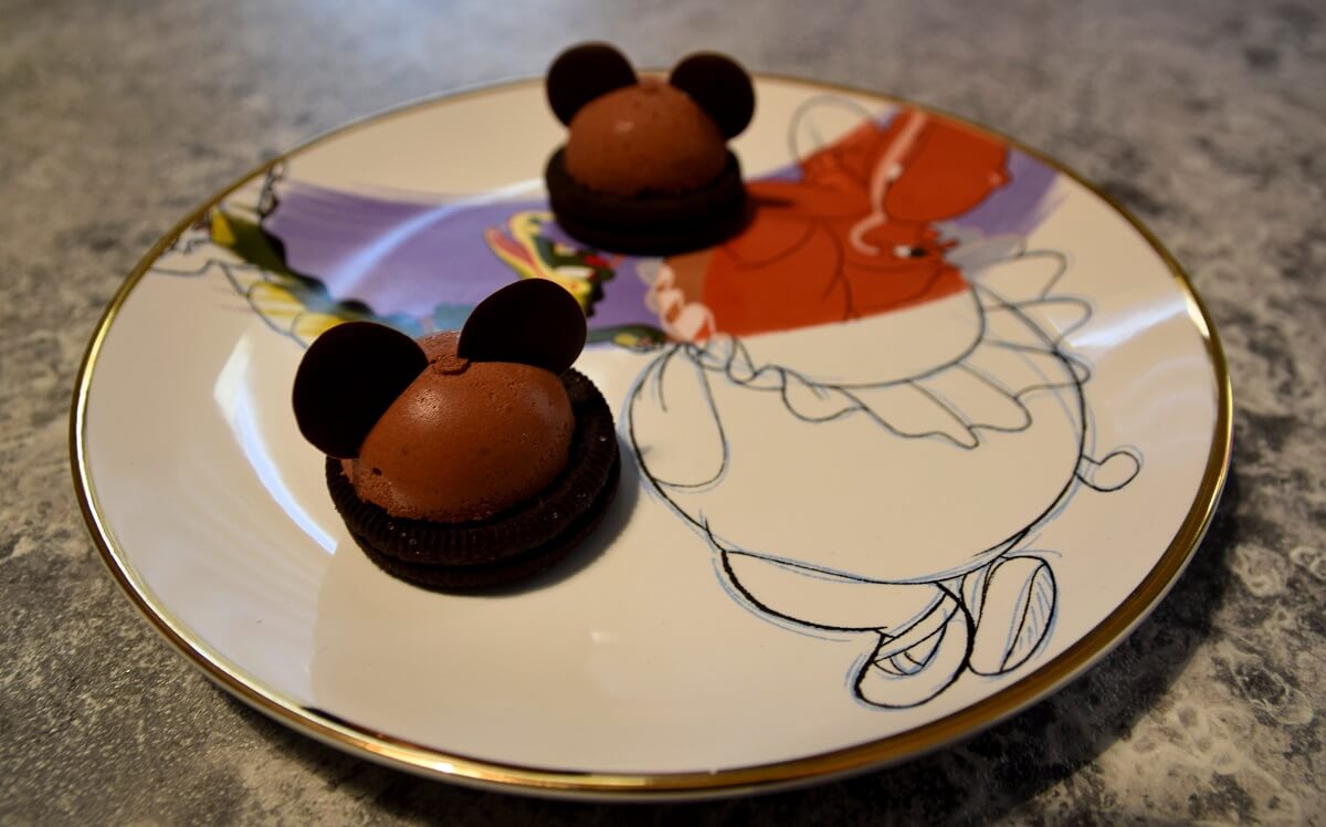 Zwei Mickey Mousse Domes liegen auf einem Teller mit Fantasia-Motiv