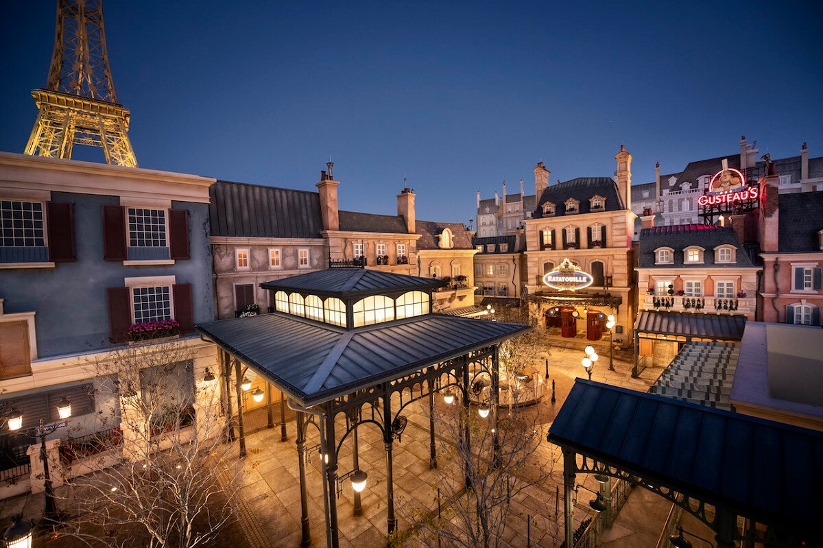 Ein Fotografie bei Nacht zeigt den wunderschön erleuchteten Platz vor der neuen Ratatouille-Attraktion im Frankreich-Pavillon in Epcot