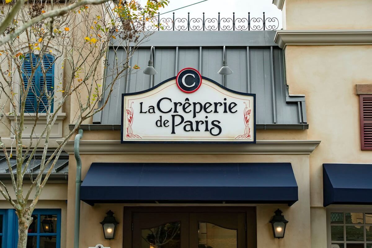 Blick auf die Fassade und das über dem Eingang hängende Schild des neuen Restaurants La Creperie de Paris im Frankreich-Pavillon in Epcot