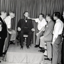 Walt Disney ist zusammen mit einigen Mitarbeitern an der Animatronic Figur von Abraham Lincoln zu sehen