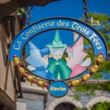 Die drei Feen Flora, Fauna und Sonnenschein aus Dornröschen zieren das Schild des Shops La Confiserie des Trois Fées im Fantasyland