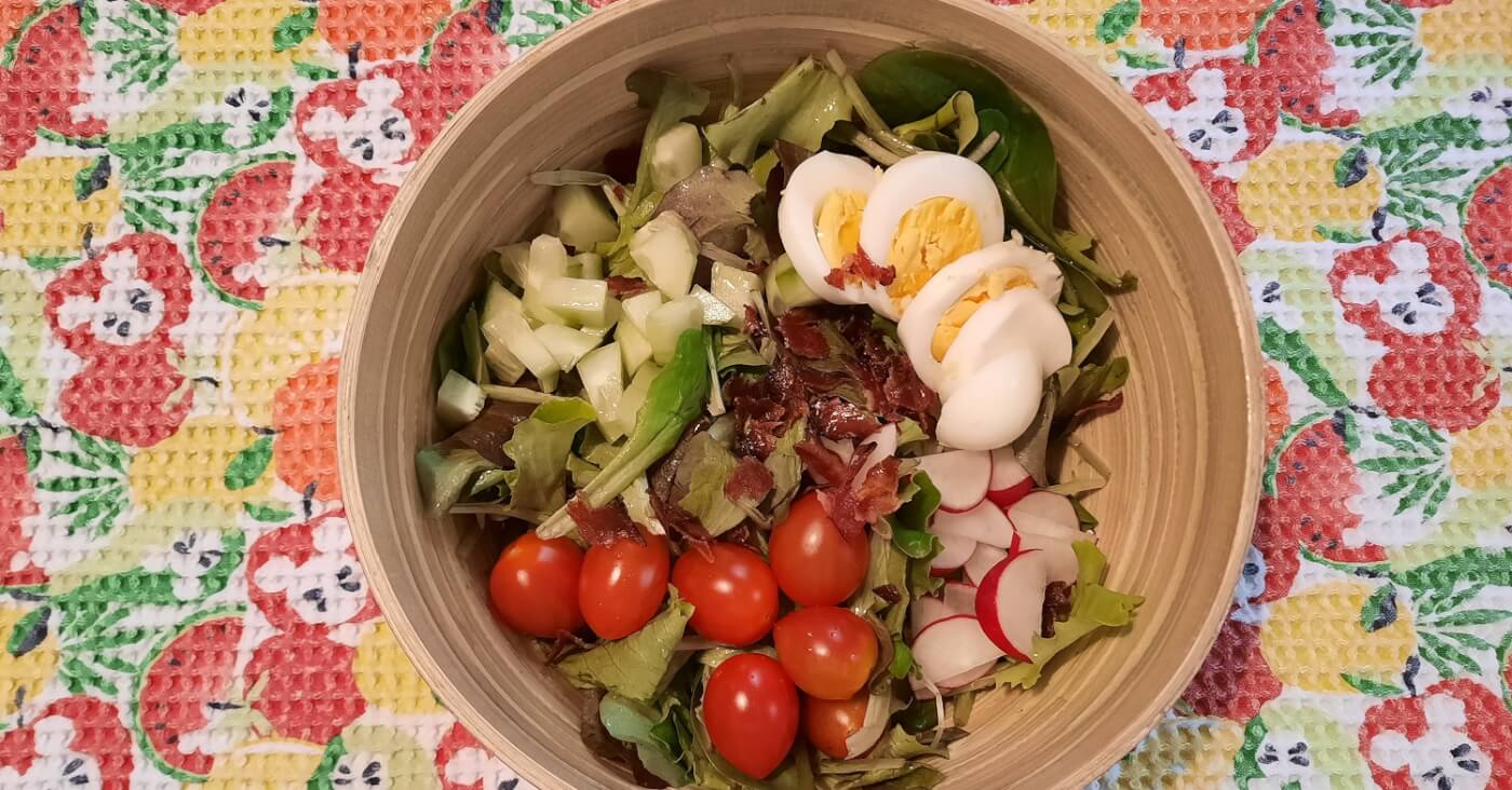 In einer Bambusschüssel ist ein Salat nach Rezept aus dem Garden Grill in Epcot mit Gurken, Eier, Bacon und einigen anderen Zutaten sichtbar