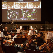 Das Orchester für das Einspielen der Musik sitzt im Tonstudio und trägt während des Spielens Chefkoch-Mützen.