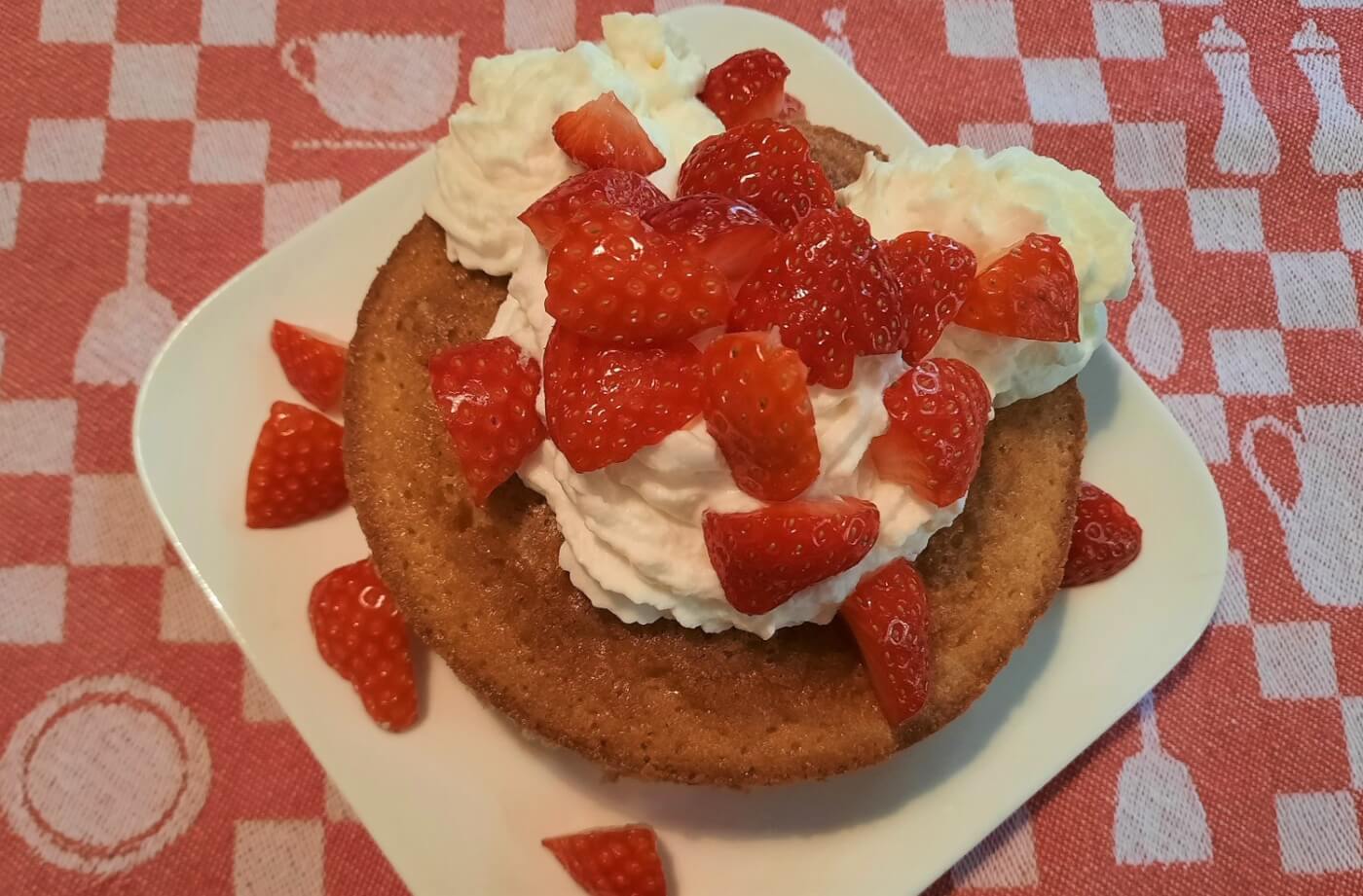 Ein Teller mit einem fertigen Strawberry Shortcake mit Schlagsahne