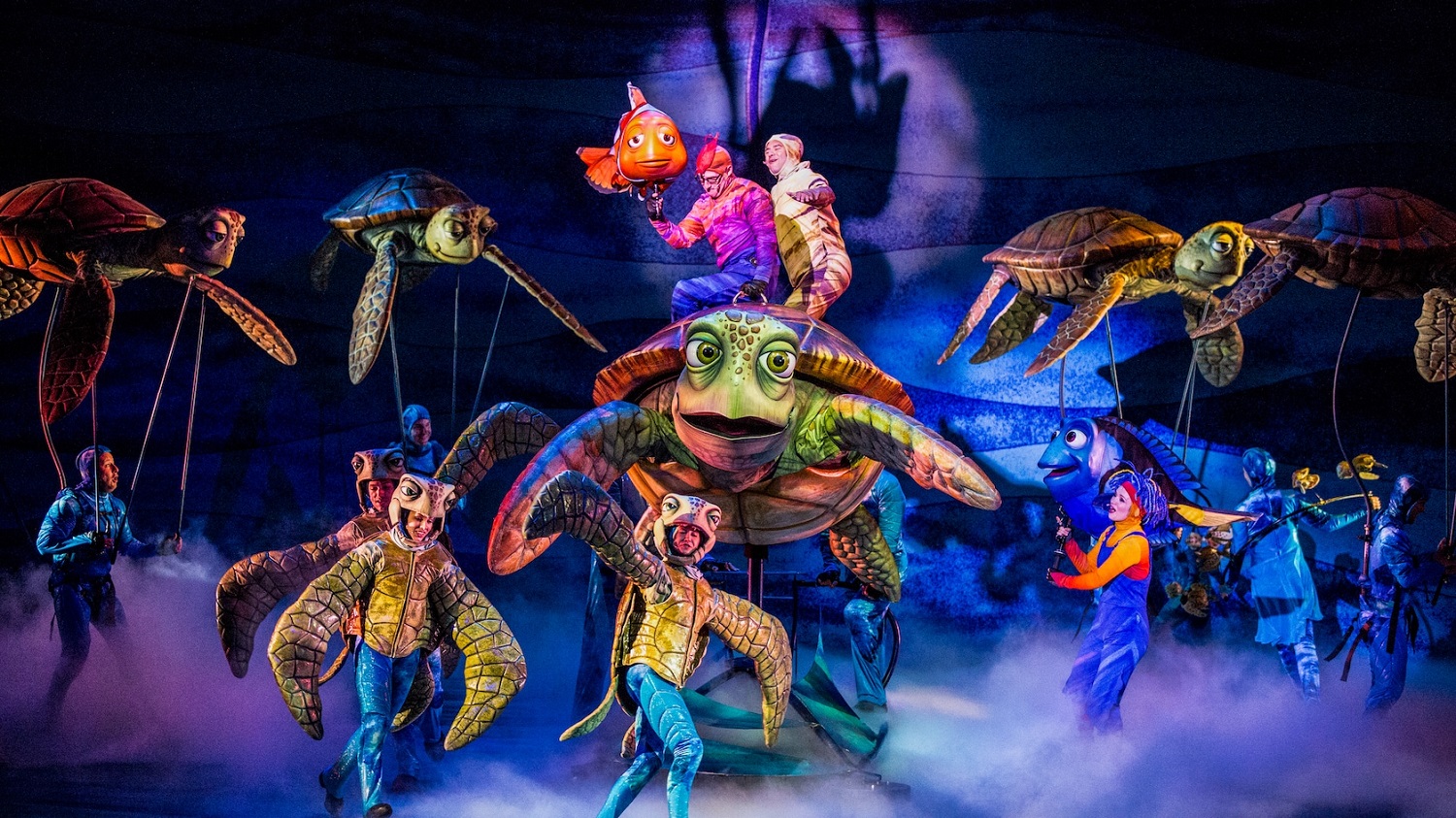 Auf der Bühne von Finding Nemo The Musical sind Tänzer und Puppenspieler in Kostümen zu sehen