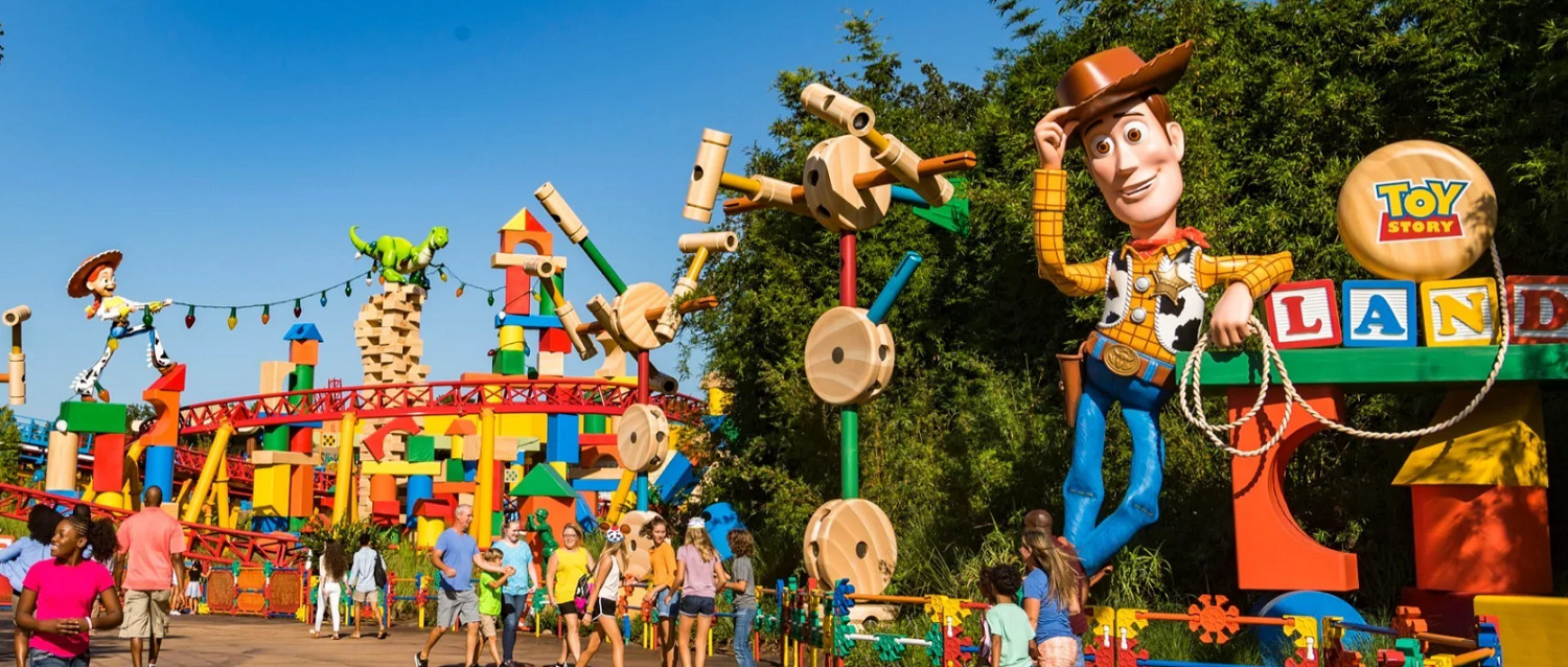 Eingang zum Toy Story Land mit einer großen Woody-Figur rechts vorne und einer Achterbahn im Hintergrund