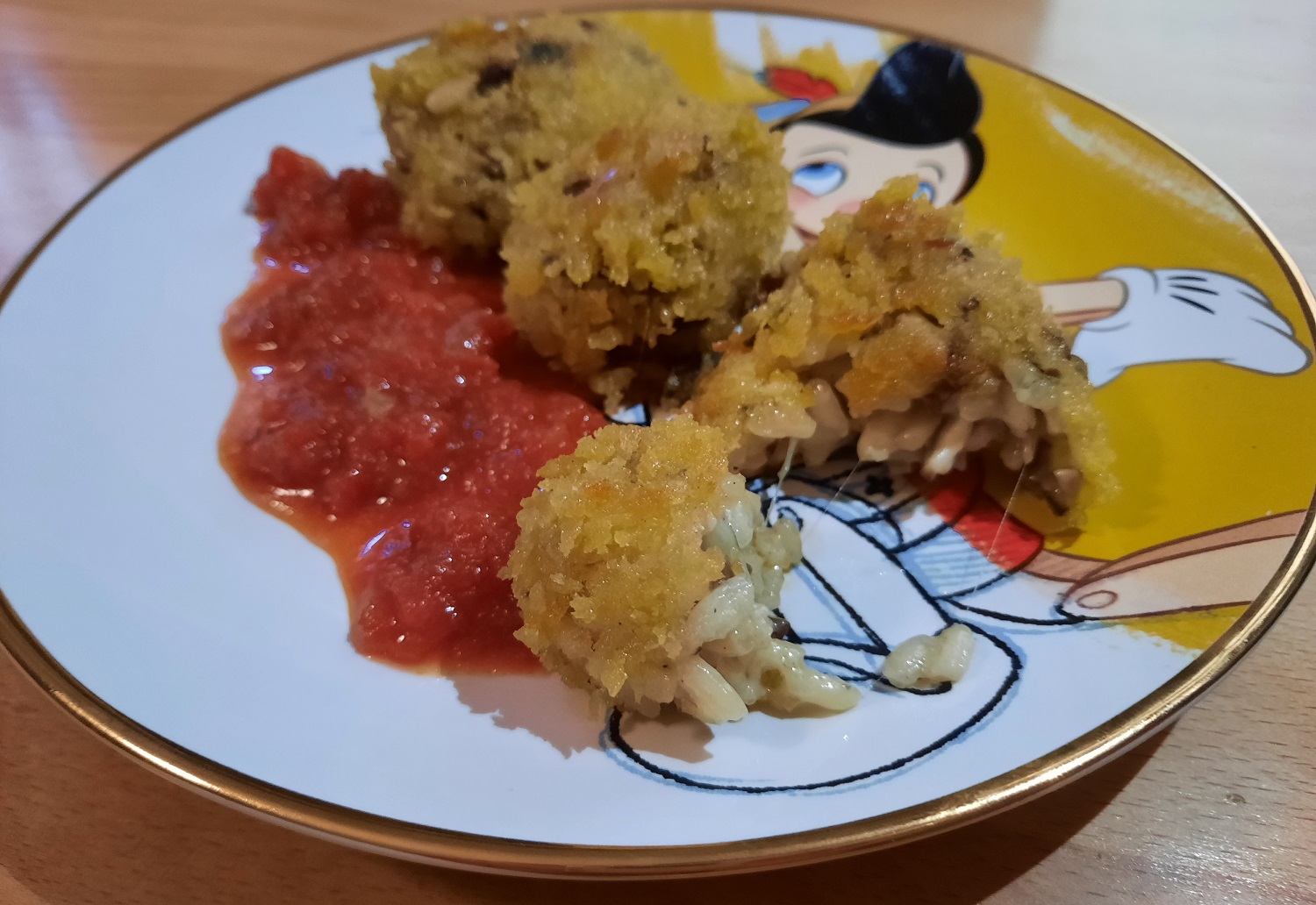 Drei frittierte Arancini mit Tomatensauce