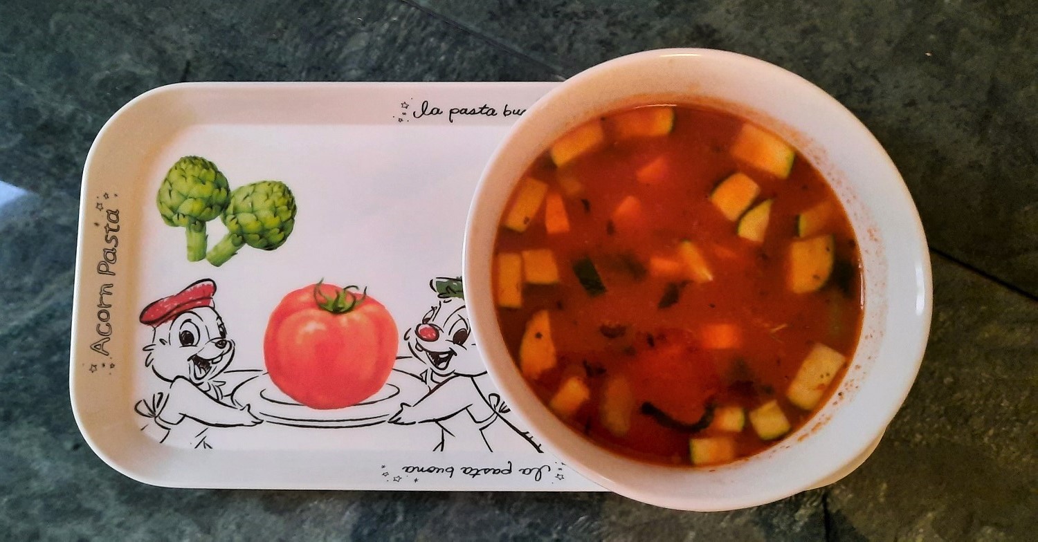 Eine Schüssel mit Minestrone-Suppe steht auf einem Tablett mit Chip und Chap-Dekor