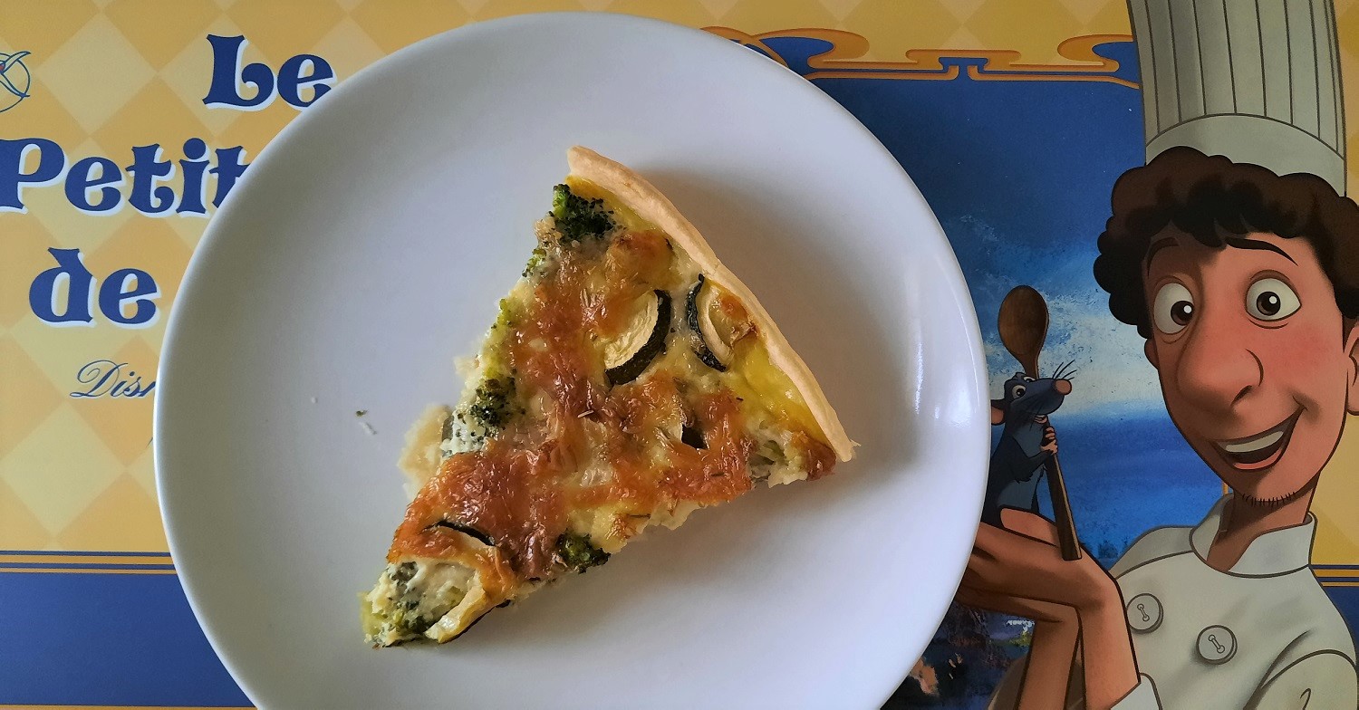 Ein Stück Gemüse-Quiche auf einem Platzset mit Ratatouille-Motiv