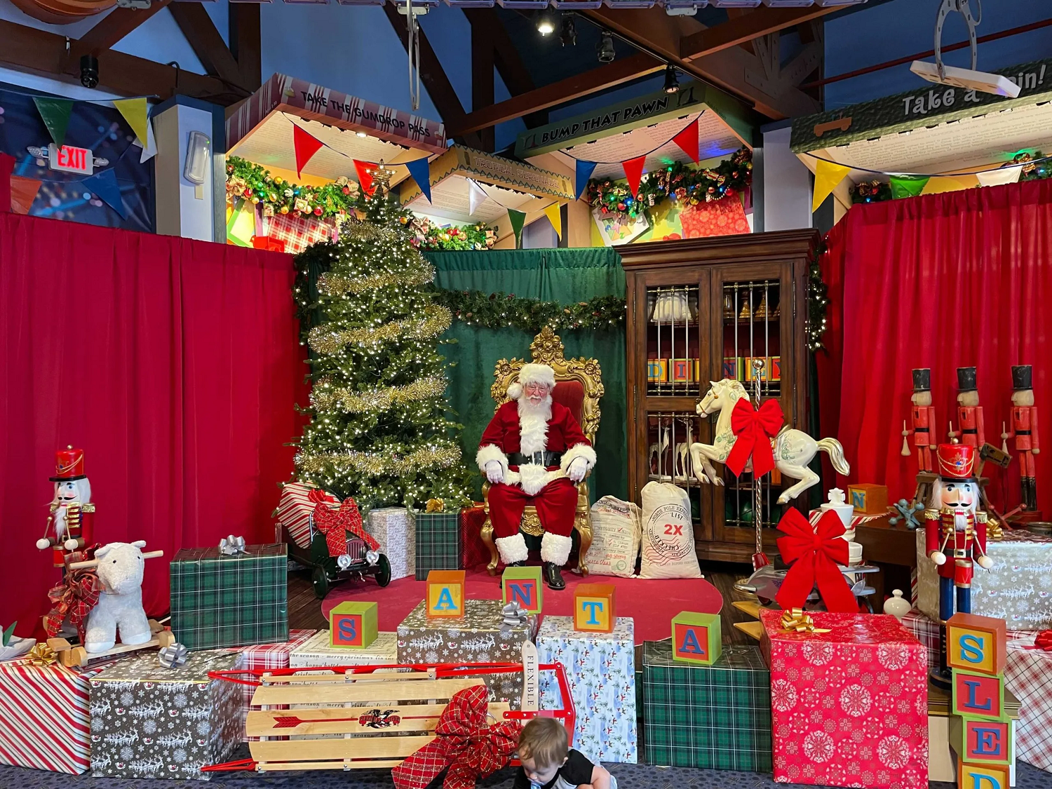 Santa Claus sitzt umgeben von allerhand Geschenken und festlicher Dekoration im Shop Once Upon a Toy in Disney Springs