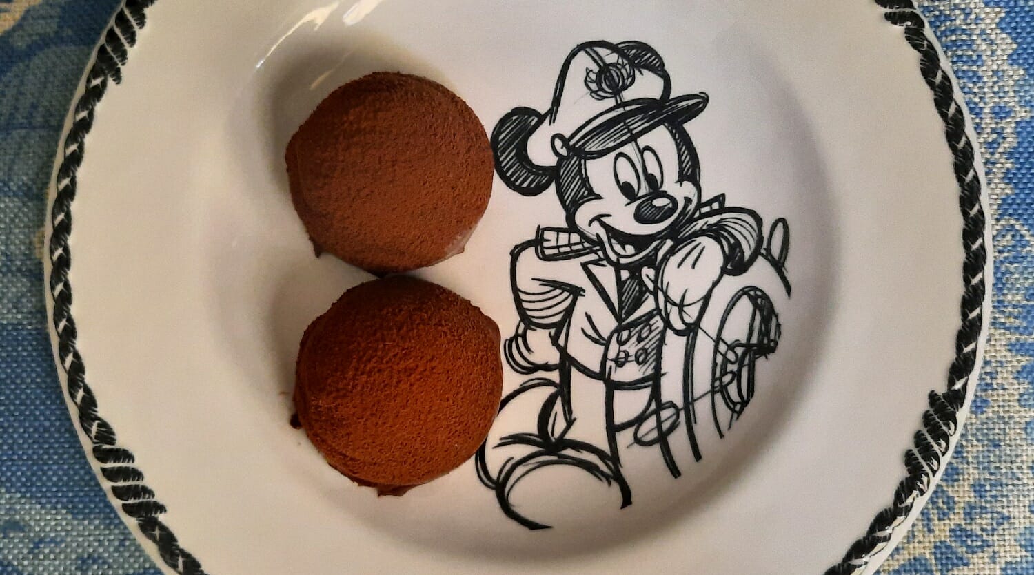 Zwei kleine Desserthäppchen auf einem Teller mit Mickey Mouse Motiv