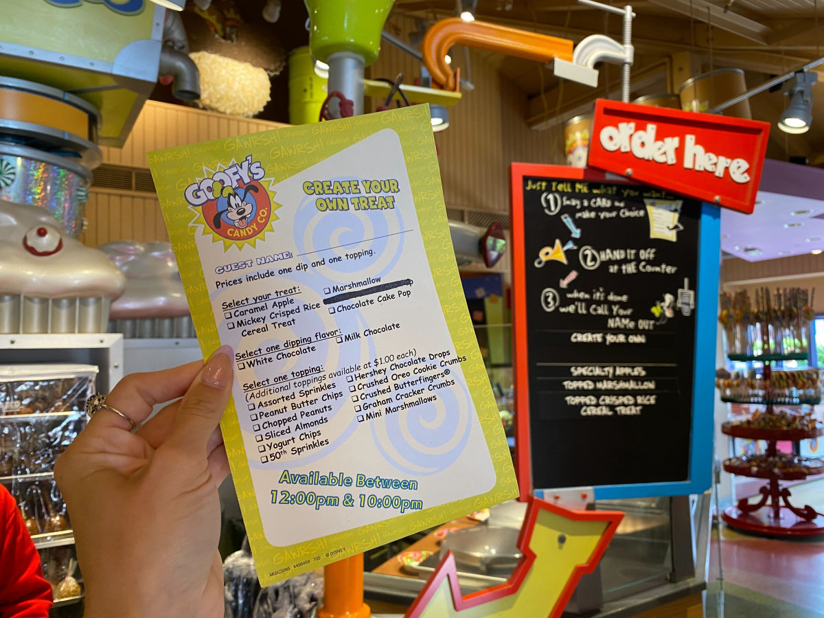 Ein Zettel für das Bestellen eines selbst zusammengestellten süßen Snacks bei Goofy's Candy Co. wird in die Höhe gehalten