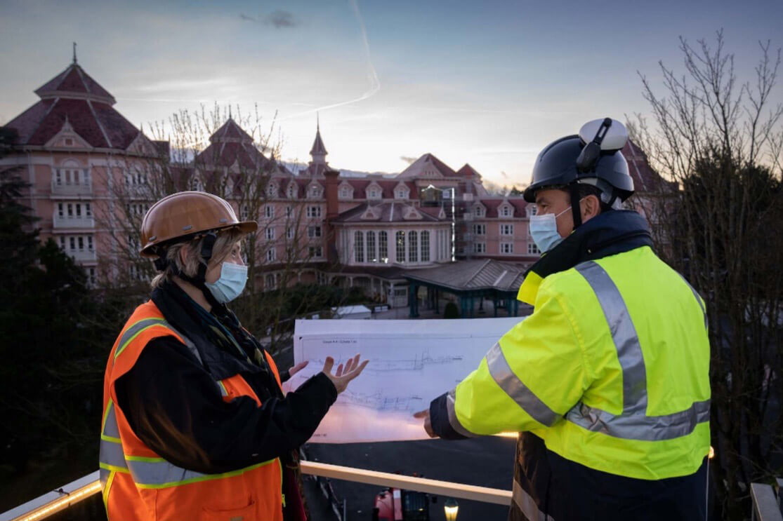 Imagineers mit Umbauplänen vor dem Disneyland Hotel