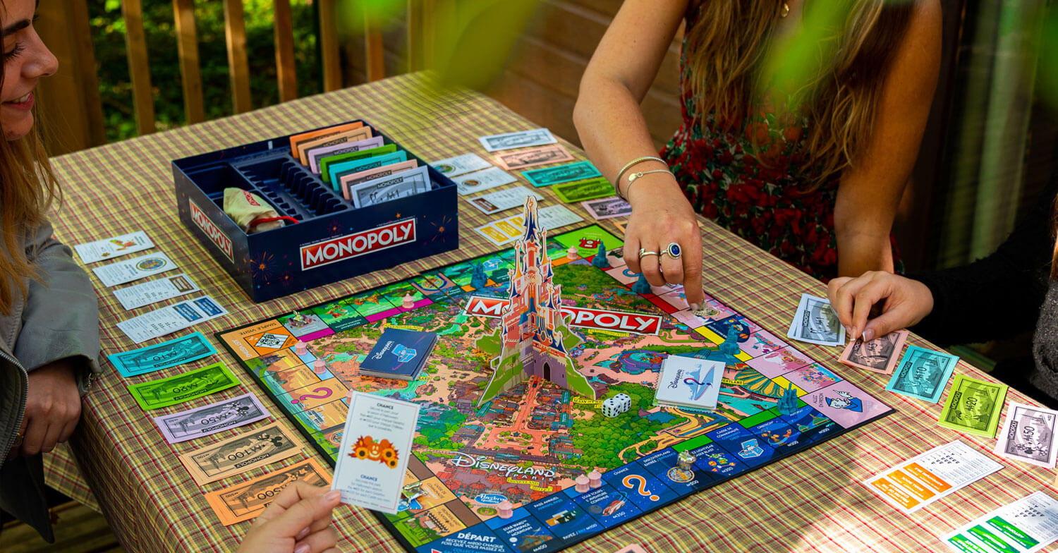 Disneyland Paris Monopoly Spielbrett mit Spielern am Tisch