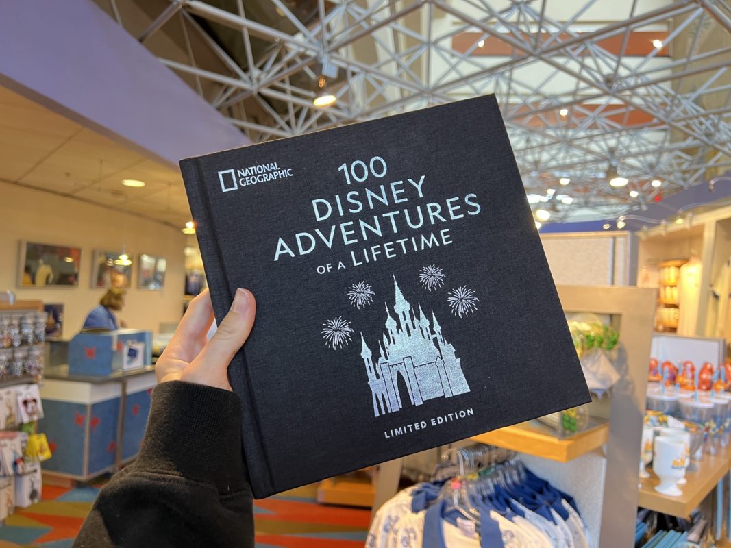 Ein Buch mit schwarzem Einband und dem Titel "100 Disney Adventures of a Lifetime"