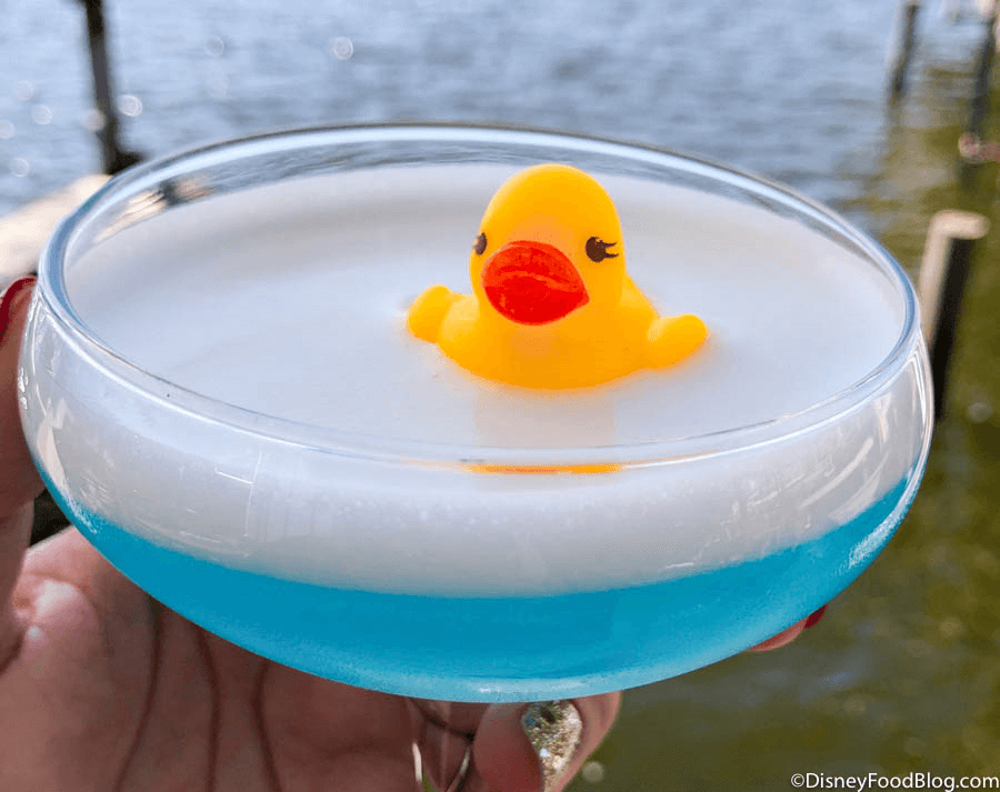 Blauer Cocktail mit weißem Schaum und einer kleinen Gummiente