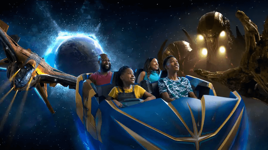 Eine Familie sitzt in einem Wagen der Achterbahn Guardians of the Galaxy Cosmic Rewind