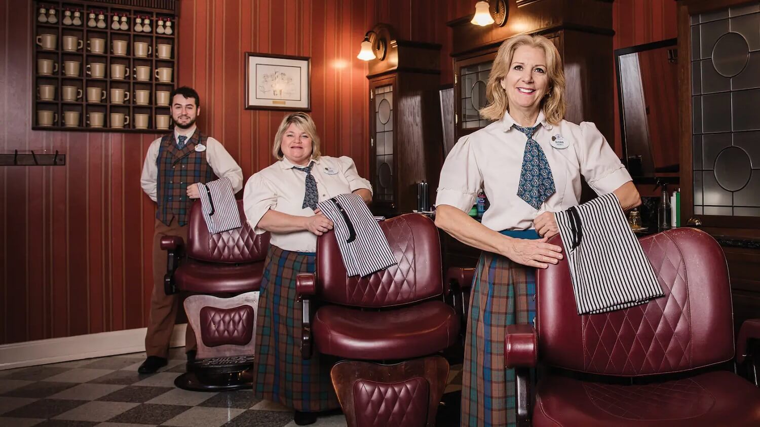 Drei Cast Member stehen im Harmony Barber Shop auf der Main Street USA