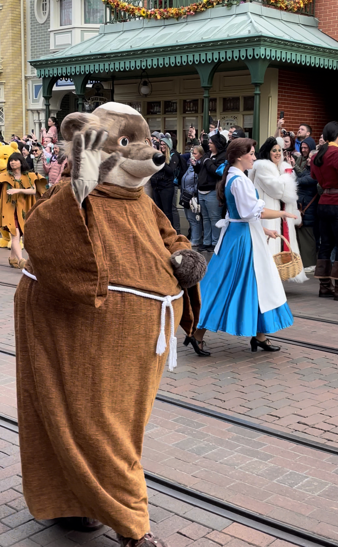 Bruder Tuck und im Hintergrund Belle und Cruella deVille bei der Disney 100 Parade in Disneyland Paris