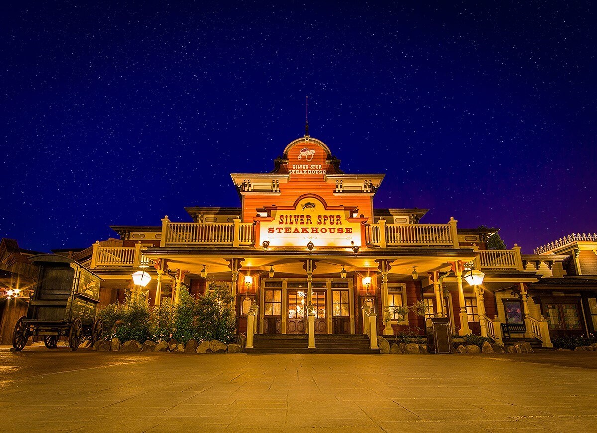 Blick auf die Fassade des Silver Spur Steakhouse, die bei Dunkelheit stimmungsvoll beleuchtet ist