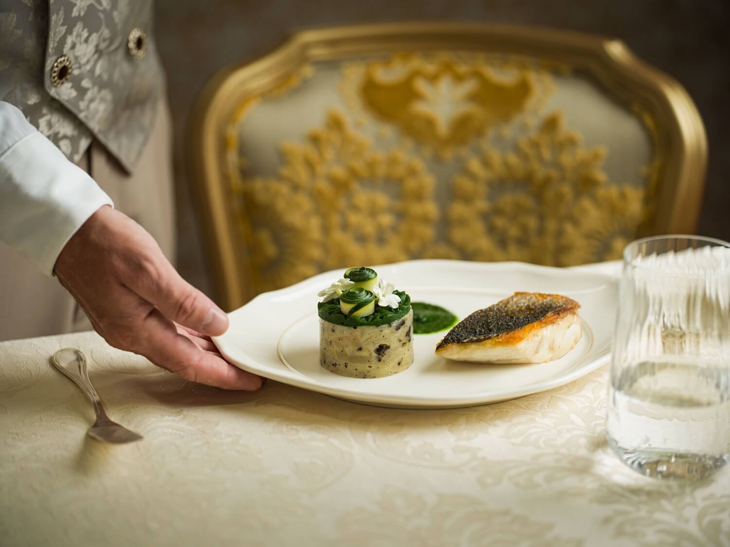 Ein Kellner serviert ein Fischgericht im Restaurant La Table de Lumiere