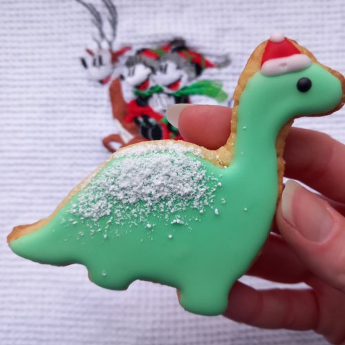 Weihnachtsplätzchen in Form eines Dinosauriers mit roter Weihnachtsmütze