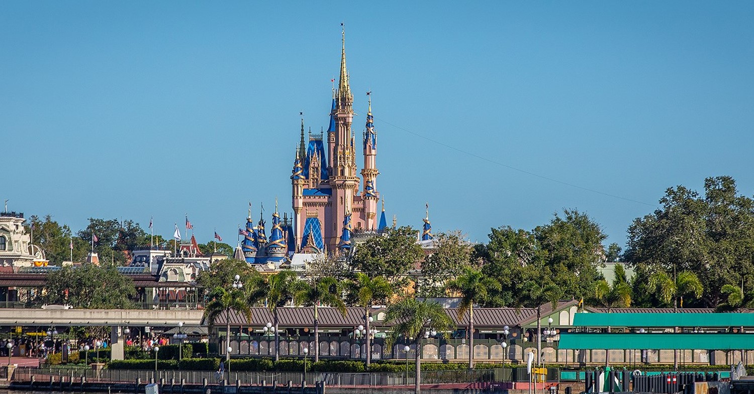 Cinderella Castle vor blauem Himmel, davor der Bootsanleger und Eingangsbereich des Magic Kingdoms