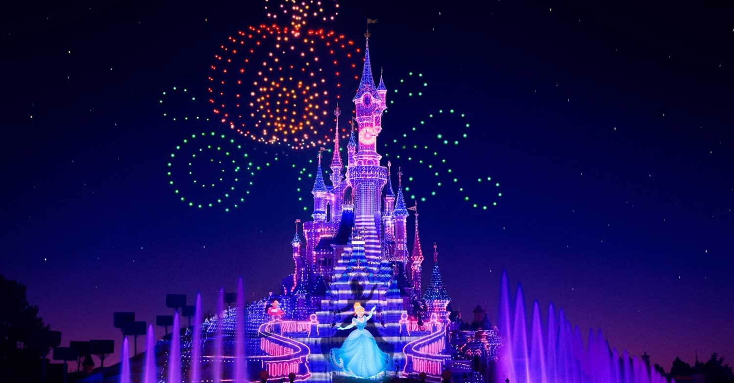 Drohnen in Electrical Sky Parade formieren sich zu einer Cinderella Kutsche am nächtlichen Himmel